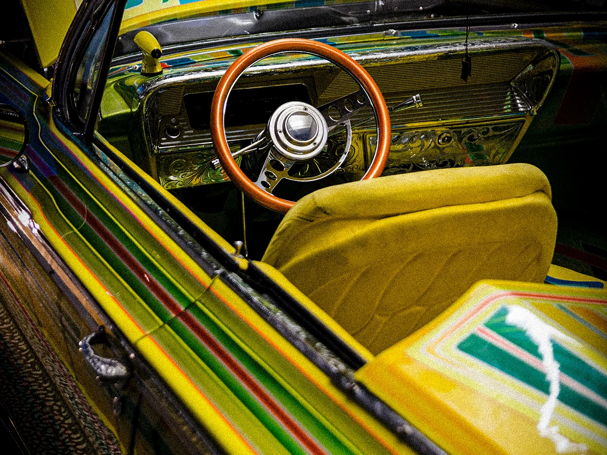 A beautiful, artistic paintjob with a metallic finish on a classic, vintage American car.